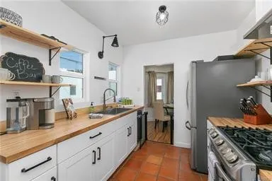 Galley Kitchen with Spanish Pavers, Butcher Block Counters, White Cabinets & Stainless Appliances