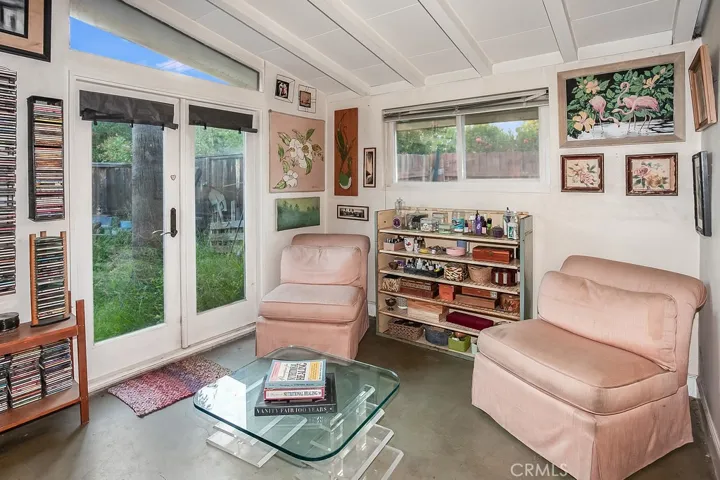 The primary suite has been expanded by incorporating one of the additional 2 bedrooms into its footprint and it is drenched in natural light from an oversized picture windows and is enriched with pitched wood beamed ceilings, ceiling fan, mirrored wardrobe doors, a huge retreat with French doors that lead to the backyard.