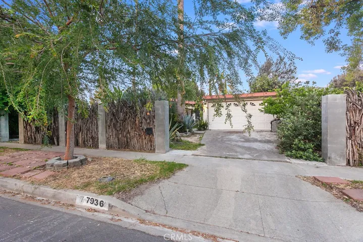Front yard with decomposed granite pathways flanked by stones, abundant eco-friendly plants, Birds of Paradise, fragrant roses, assorted flowering shrubs; plus a gated entryway that opens to a private patio that is perfect for quiet relaxation.