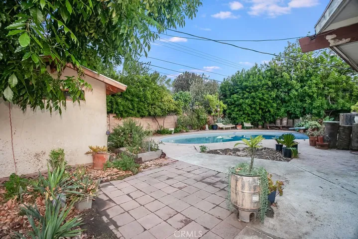 Large entertainers backyard with in-ground pool, open patio, colorful flowerbeds, tall shade and fruit trees – Meyer lemon, orange, apricot and guava.
