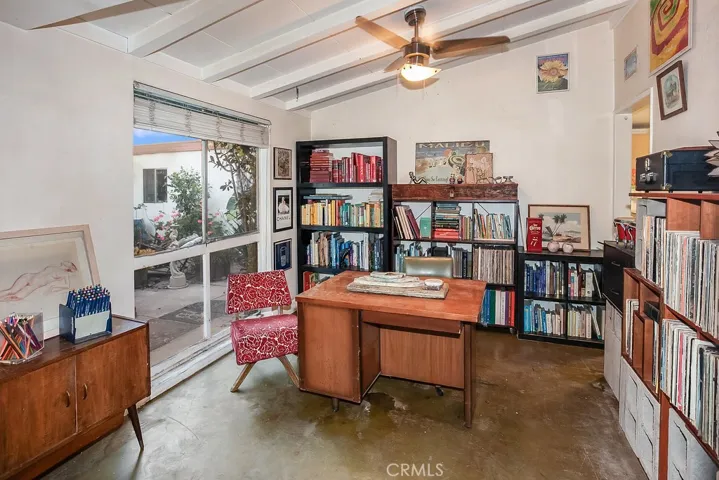 Separate den/office/formal dining room with beamed ceilings, lighted ceiling fan, large picture window and concrete floors. (Offers the potential to be an additional bedroom).