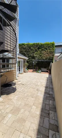 Side yard with lower level covered patio/seating area.