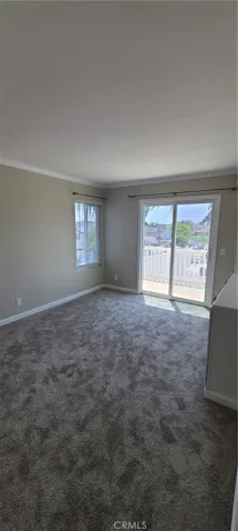 Third bedroom with built-in cabinetry and sliding door access to front balcony.