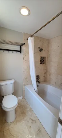 Primary bathroom with sunken tub/shower combo.