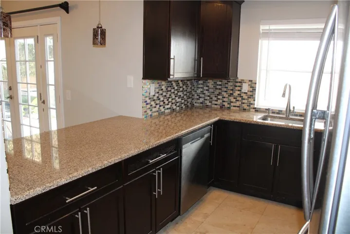 Kitchen with breakfast bar, adjacent to family room.