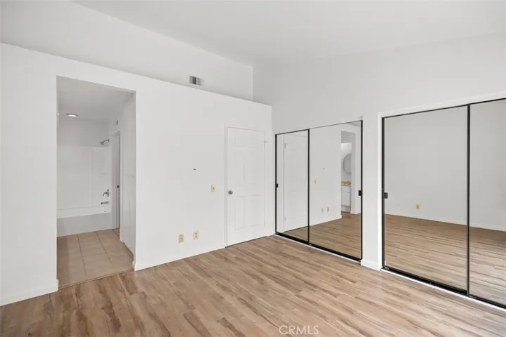 Primary bedroom with mirrored closet doors and en suite bathroom