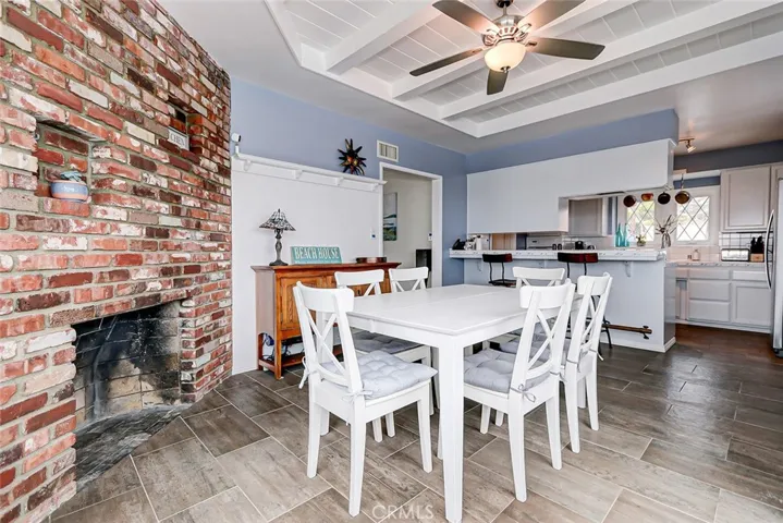 View of dining area and fireplace with kitchen in background