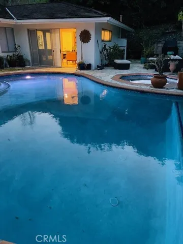 Twilight view of pool and primary bedroom