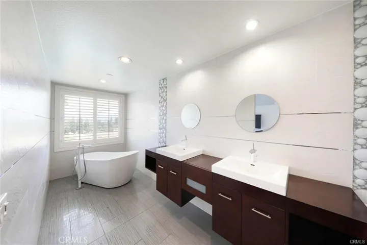 master bathroom with dual vanities and custom lighting