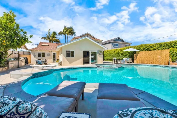 Amazing Backyard Wraps Around Home with BBQ, Dining Area, Fire Ring Sitting Area, Newer Deck Area, Spa, Diving Board, and Tropical Landscaping