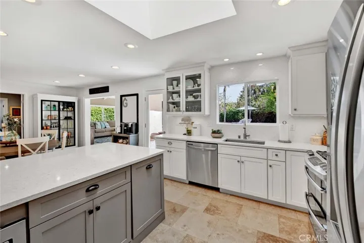Quartz Counters, Skylight, Recessed Lighting, Breakfast Bar, Stainless Appliances, Walk-In Pantry, Custom White Shaker Self-Closing Cabintry with Under Cabinet Lighting, Pull-Outs, Hidden Trash, and Glass Display Panels