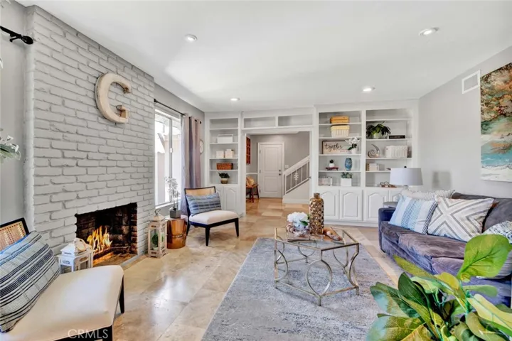 Living Room has Travertine Floors, Fireplace, and Custom built-In Cabinetry