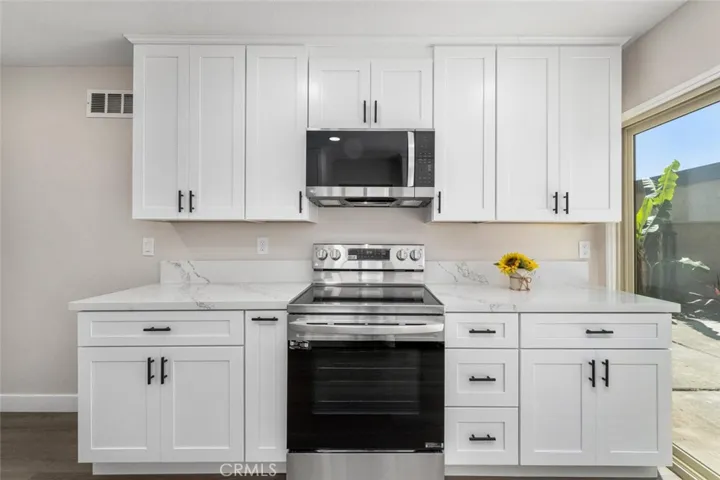 Stainless steel appliances include gas range, microwave, dishwasher, sink with upgraded faucet and fixtures.