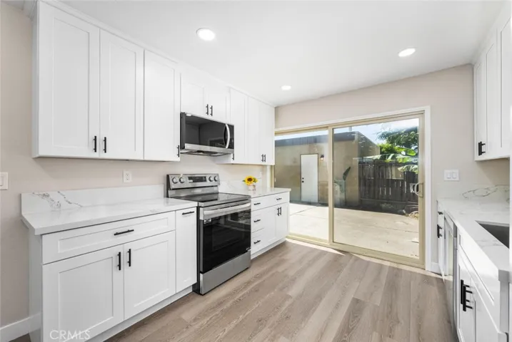 Remodeled kitchen featuring quartz countertops and shaker style cabinetry.