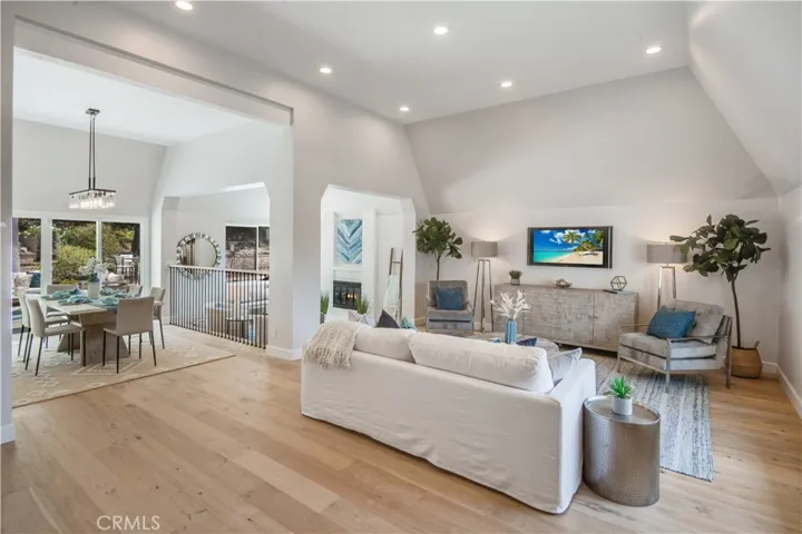 Living room open to dining room, to den with fireplace (photographer graphically inserted fire for this photo)