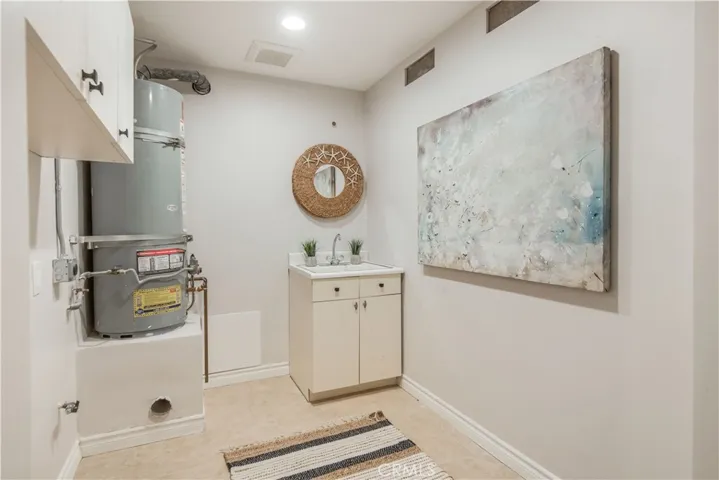 Separate laundry room with sink, cabinets, on main floor.
