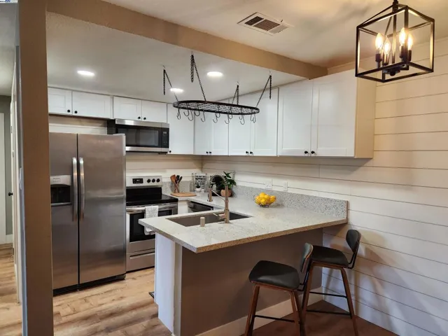 Updated kitchen with stainless appliances, stone counter tops and white shaker cabinets