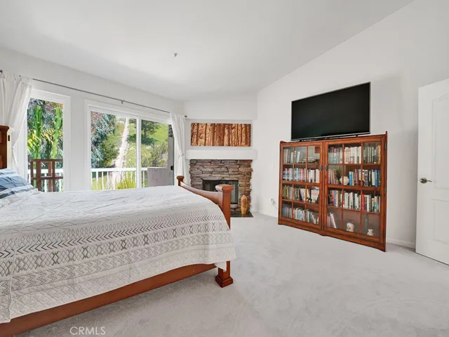 Another view of the primary bedroom, notice the vaulted ceilings and natural light.