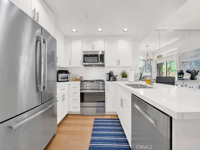 The chef's kitchen is totally remodeled with stainless steel appliances, quartz countertops, custom cabinets and more.