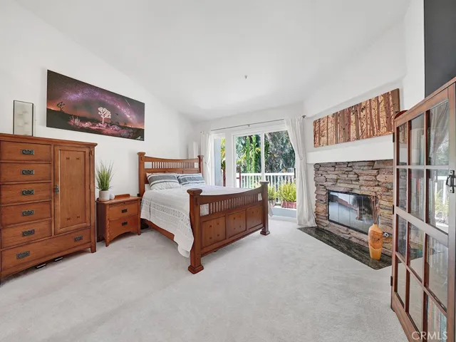 The primary bedroom has vaulted ceilings and a view of the hillside.