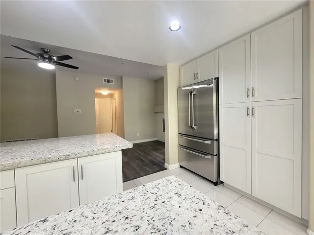 Kitchen refrigerator surrounded by more canbinets