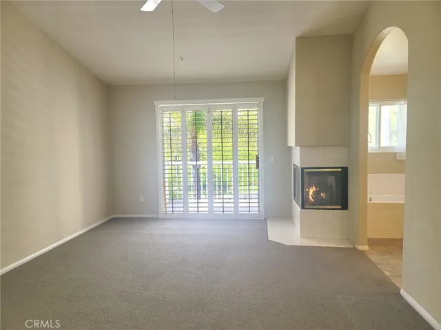 Primary bedroom with cozy fireplace and access to balcony