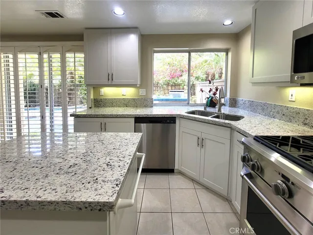Kitchen has nice size island in the center & sliding door access to backyard