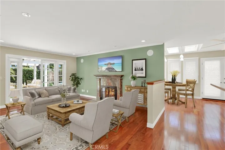 Living room with fireplace and French doors leading to the backyard.  Living room and dining area Virtually Staged
