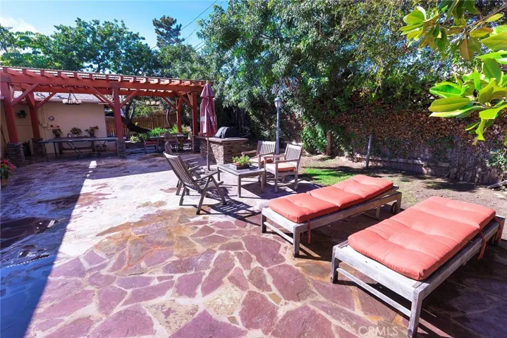 Large stone patio with covered pergola and barbecue station for your own barbecue