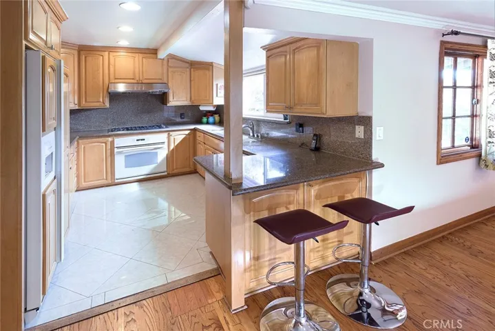 Kitchen with stone counters, built-in refrigerator and breakfast bar