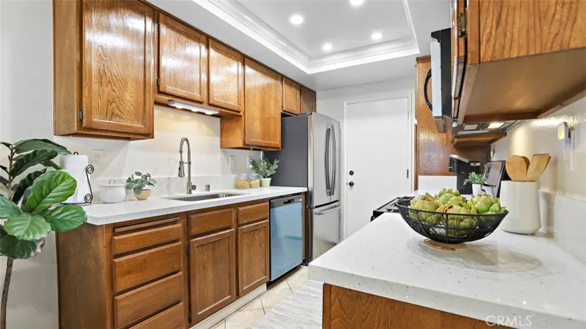 Updated w beautiful quartz countertop, backsplash, sink, faucet, garbage disposal, recessed light on dimmer, newer refrigerator & brand-new dishwasher.