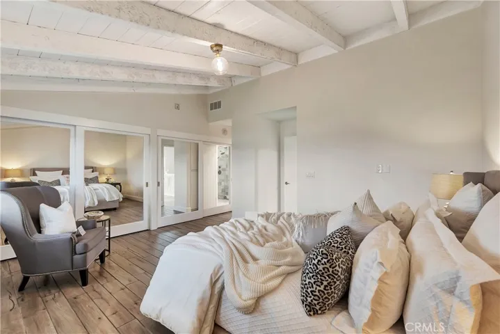 Primary Bedroom Suite with Wall of Mirrored Closets by California Closets
