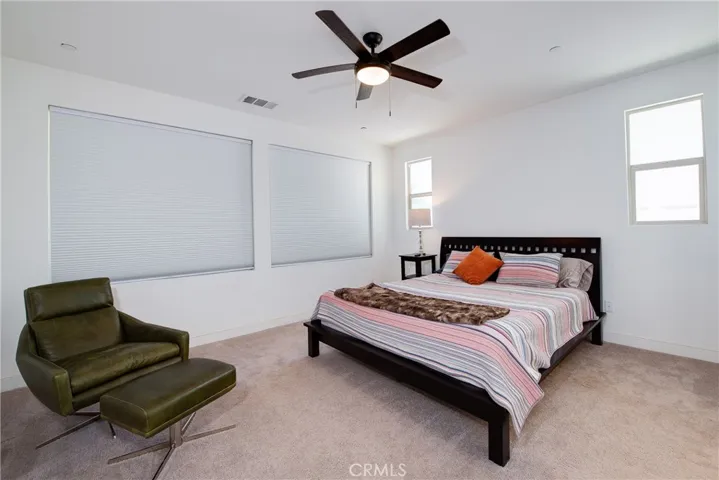 The roomy primary bedroom is downstairs with multiple windows and a ceiling fan to keep you cool on those warm days and overlooks the backyard.