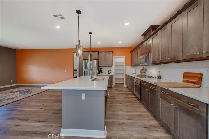 The cook in the family will enjoy the multiple dark cabinets highlighted by the white quartz countertop, the large kitchen island and walk in pantry.
