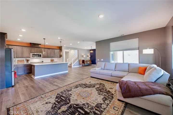 The living room opens into the kitchen. The large kitchen island has pendant lighting and seating for at least five.