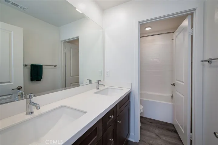 The upstairs bathroom has dual sinks and a shower/bathtub combination.