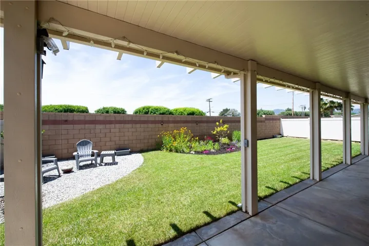 The covered patio extends the length of the home. Notice there is no neighbor behind the home.