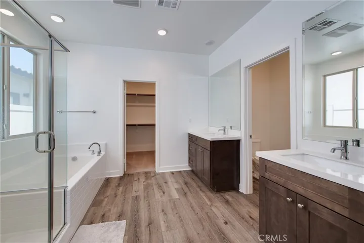 The primary en-suite has dual sinks, a separate shower and bathtub along with a large walk in closet.