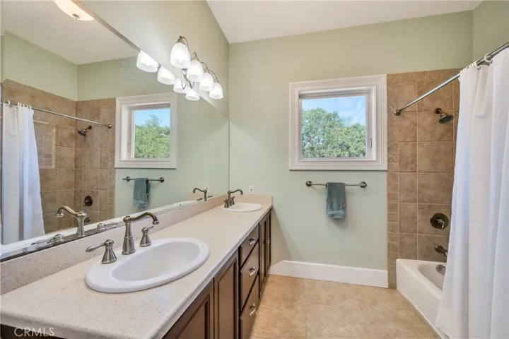 Hall Bath with dual sinks, tub shower combo & linen cabinet