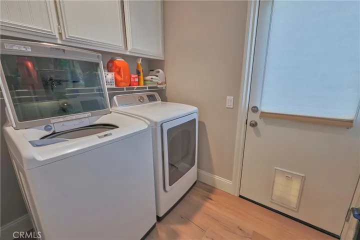 Indoor laundry room with door to sideyard.