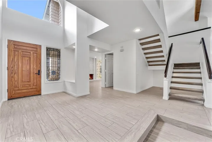 Large Entry Foyer with Stained Glass Window Next to Door and Large Arched Window Above the Door
