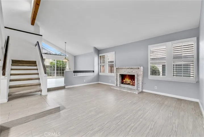 Step Down Formal Living Room with Gas Fireplace and Exposed Beam Vaulted Ceiling