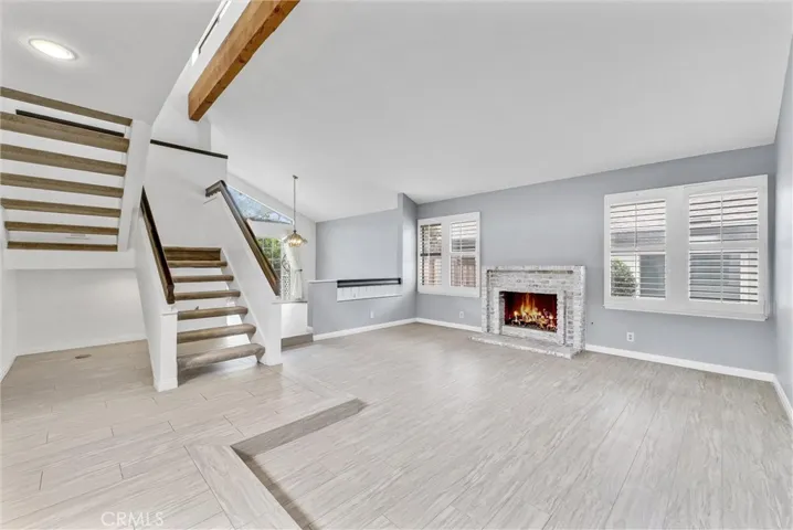 Step Down Formal Living Room with Gas Fireplace and Exposed Beam Vaulted Ceiling