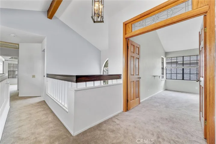 Upstairs with Open Beam Cathedral Ceiling and Primary Suite Entry