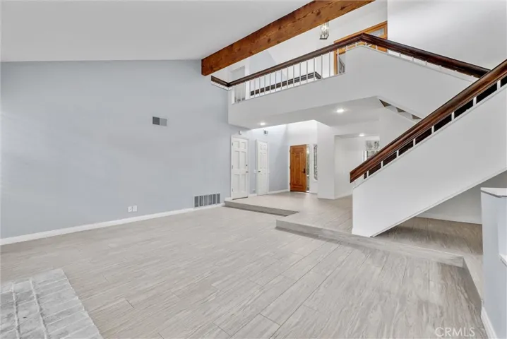 Step Down Formal Living Room with Gas Fireplace and Exposed Beam Vaulted Ceiling