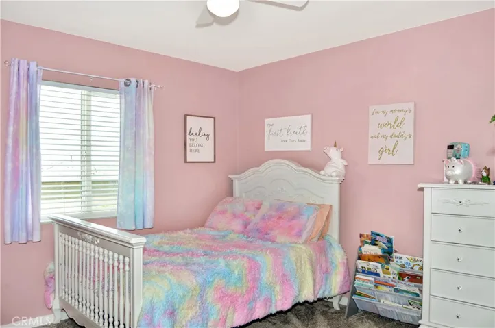 The 3rd bedroom is on the other side of the loft from the first two bedrooms, offers a walk-in closet, window blinds, a ceiling fan, and pretty pink paint