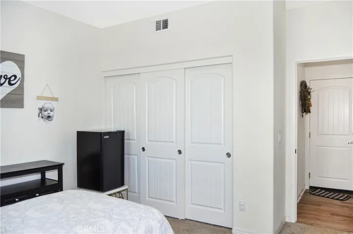 The main floor 5th bedroom offers views of the backyard, a ceiling fan, and easy access to the full bathroom next door.