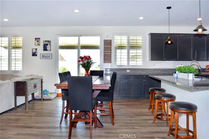 The dining area is perfectly located between the living area and the kitchen and offers access to the covered patio, backyard views, recessed lighting, and more of that luxury waterproof flooring