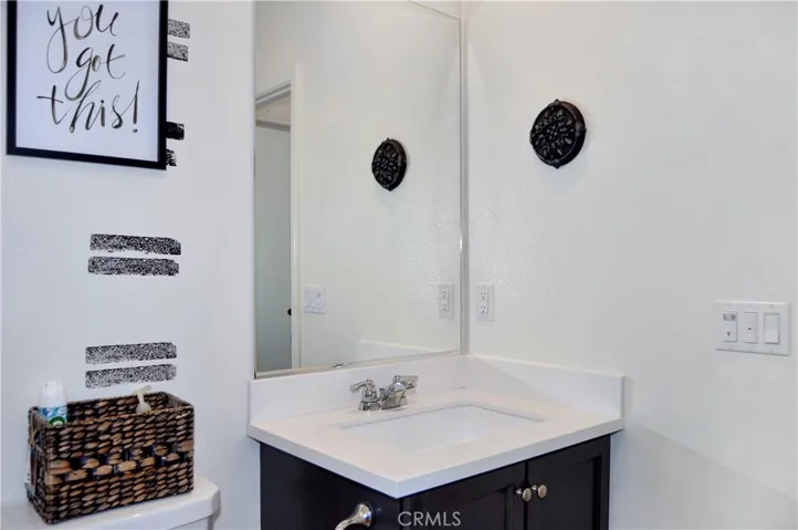 The 3rd bath is on the main floor and provides a walk-in shower, wainscoting accents, dark cabinetry, and more luxury vinyl plank flooring that guests are sure to love