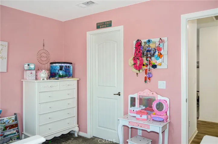 The 3rd bedroom is on the other side of the loft from the first two bedrooms, offers a walk-in closet, window blinds, a ceiling fan, and pretty pink paint